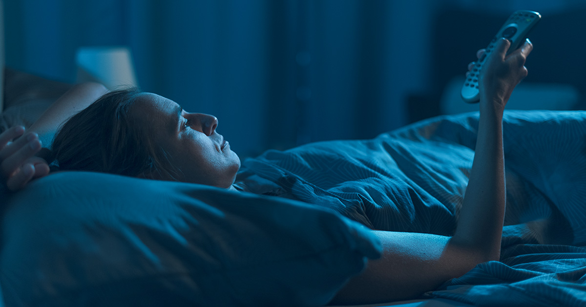 Person illuminated by the blue light of a screen