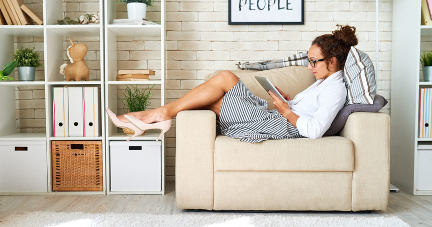 femme lisant sur un ipad depuis son canapé