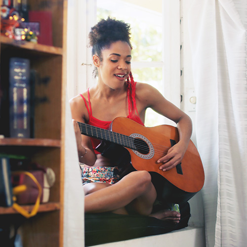 femme jouant de la guitare chez elle
