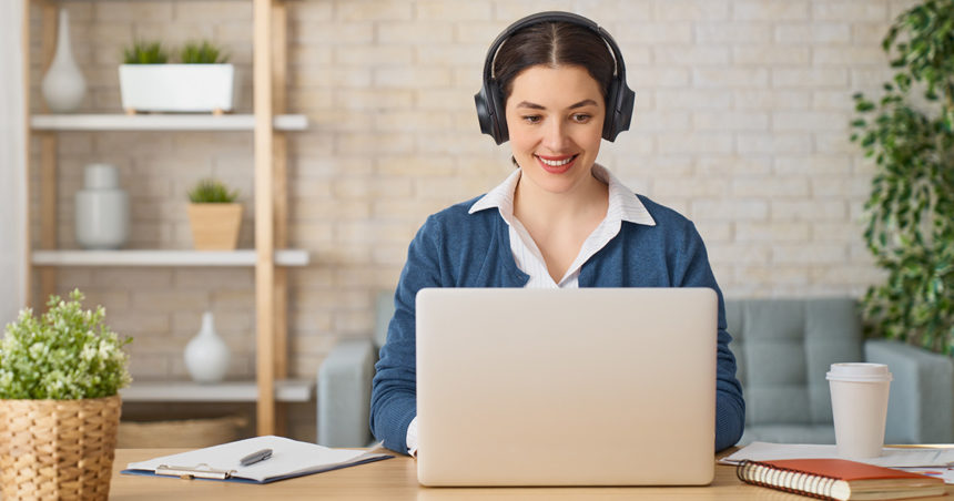 jeune femme travaillant de chez elle avec ordinateur portable et casque audio