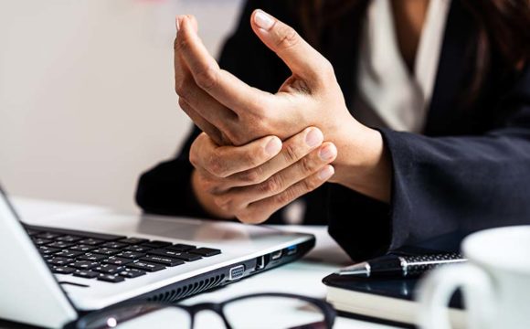 person with wrist pain works on a computer