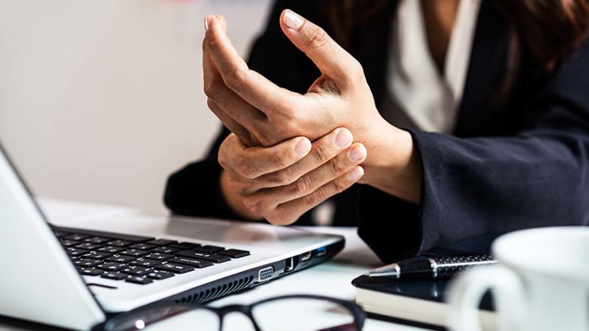 person with wrist pain works on a computer